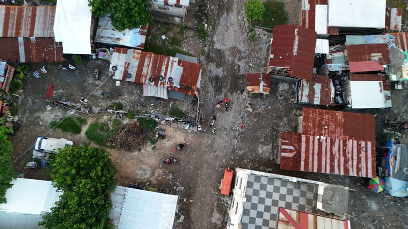 Rusted tin roofs of a dense settlement seen from directly above